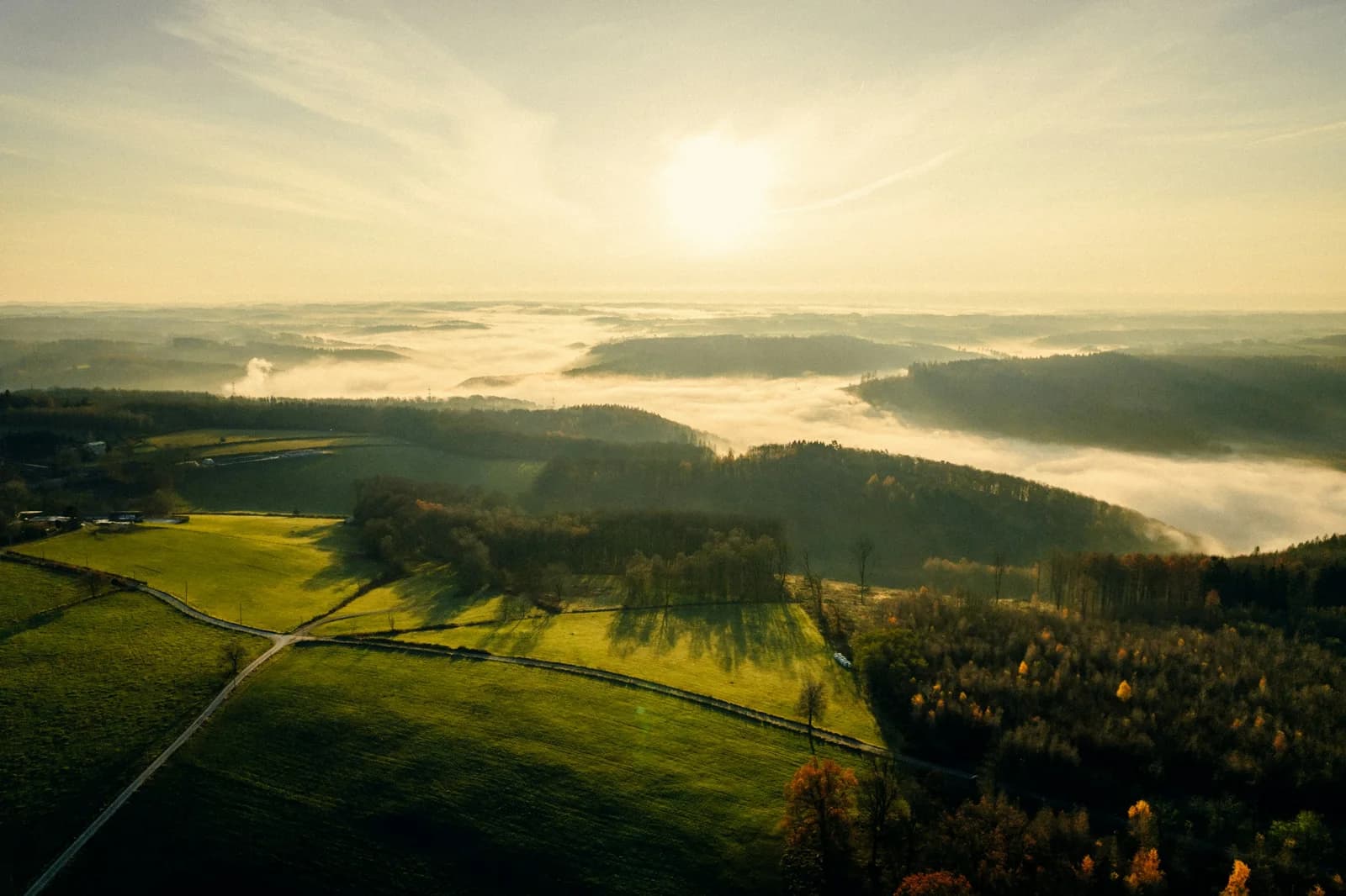 Sonnenaufgang über den bewaldeten Hügeln und nebligen Tälern des Sauerlands